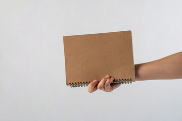 Wall Mural - Brown notebook in hand on white background