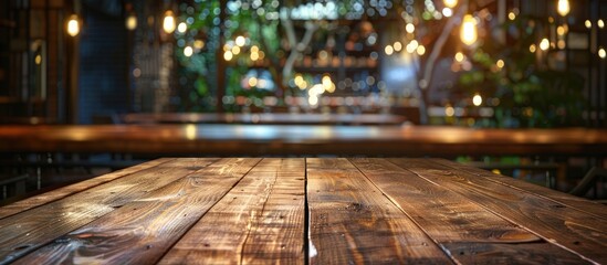 Fototapete - A spotless wooden table takes center stage in a vibrant restaurant setting at night providing a perfect copy space image for food promotions or exhibits