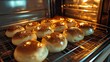 © Nuttaya Nampai - A close-up shot of homemade buns baking in a kitchen oven, with the golden crusts forming on the buns, perfect for capturing festive or daily moments