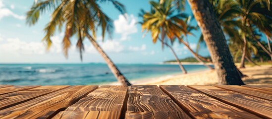 Poster - A wooden table set against a blurred summer beach with palm trees creating a scenic backdrop for showcasing summer products with copy space image