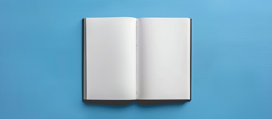 Poster - Top down flat lay of an open blank white book on a blue desk with copy space image