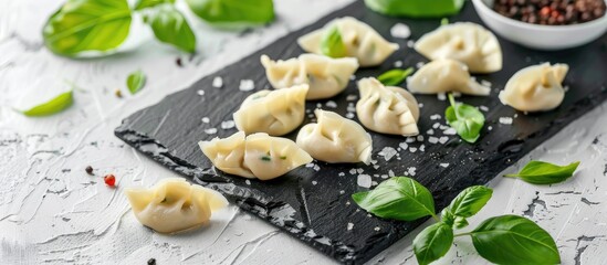 Poster - Blackboard with uncooked dumplings and basil on a white backdrop creating a visually appealing copy space image
