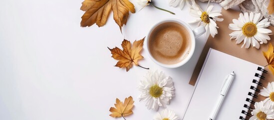 Wall Mural - Fall themed arrangement featuring a cup of coffee notepad and flowers on a white backdrop conveying an autumnal vibe with space for text or images. Creative banner. Copyspace image