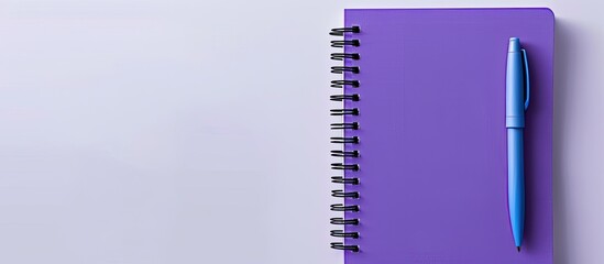 Poster - Purple notebook and blue pen viewed from above on a white background making it suitable for school or office themed wallpapers with a flat lay composition and ample copy space image