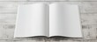 © HN Works - A blank brochure mockup on a light wood background providing a template for design shown in an A4 magazine mockup on a gray table with a page or notepad ideal for a copy space image