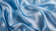 © Daria94 - Close-up of light blue satin fabric with soft, flowing folds, showcasing its smooth texture and elegant, glossy finish.