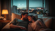 © vita - Nostalgic cinematic photo of a couple in love, lying on a sofa together, tenderly embracing. Dark night and city lights outside a window. Comfy place.