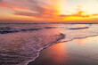 © Elloria Voltan - Serene sunset at Playa El Tunco, El Salvador, with gentle waves reflecting vibrant orange and pink hues. A tranquil seascape capturing the peaceful beauty of this popular coastal beach destination.