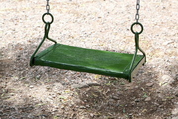 
Closeup of green colored wooden hammock with diffuse background. Traditional outdoor game for children. Playground.