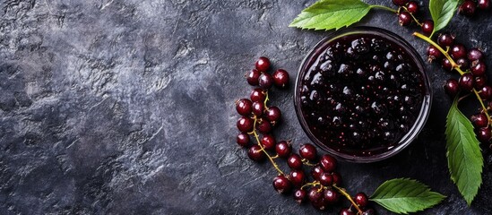 Fototapete - Jam made from black chokeberries Aronia melanocarpa and their berries on a dark table Homemade preserves Top view Horizontal. with copy space image. Place for adding text or design