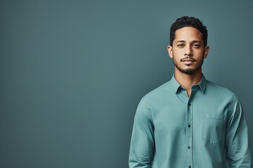 Canvas Print - A man in a blue shirt is standing in front of a blue wall