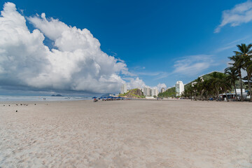 Wall Mural - Morning at Enseada Beach on a beautiful day with some clouds, a wide view of the beach sand, the sea, and the hills in the background.  Guaruja - SP, Brazil.