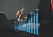 © MrPanya - Businessman sits with pen touching virtual screen, annual financial report, chart with annual statistics, company progress and growth by 2025.
