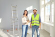 © Studio Romantic - Foreman and female apartment owner discussing future apartment design. Professional builder repairman in hardhat meeting at home to talk about renovation process, interior decoration, home layout