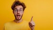 © Bos Amico - Excited energetic young man with glasses and curly hair making an enthusiastic gesture and facial expression against a bright yellow studio background  Concept of positive lively