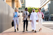 © oneinchpunch - Group of multiethnic business people meeting an emirati businessman - International corporate business team bonding outdoors in the city