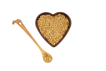 Green lentils in wooden bowl on isolated white background. Top view, copy space. Flat lay.