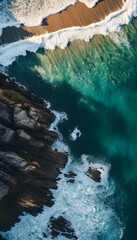 Wall Mural - Aerial view of ocean waves crashing on the shore, showcasing the vibrant blue water and white foam. The image captures the beauty and tranquility of the sea.