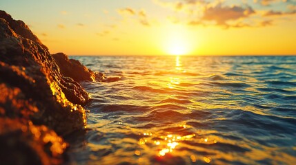 Golden sunset over the ocean with rocky shoreline