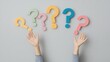 © olga_demina - Colorful question marks with raised hands against a neutral background. Concept of curiosity and inquiry.