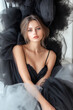 © wuttichai1983 - A beautiful woman with captivating eyes, dressed in a black tulle gown, posing gracefully.