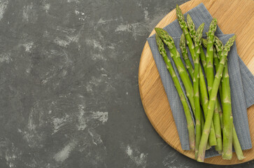 Fresh asparagus on concrete background, top view