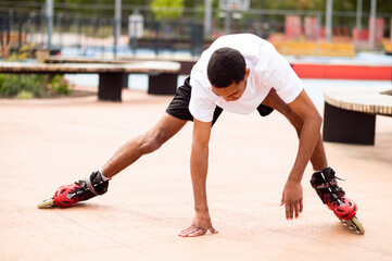 Young man on rollers trying to keep balance and starting to fall down