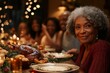 © Halina Berah - Several African American women are smiling in the decorated dining room at home during a family Christmas dinner