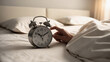 © Olena Yefremkina - A man's hand turns off the alarm clock.