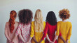 © whoopwhoops - background for international womens day, different skin color and race holding each other hand, shot from behind.