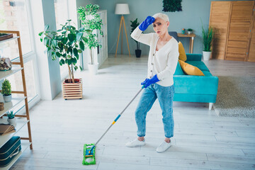 Poster - Photo of attractive tired senior woman wear white cardigan doing cleaning routine indoors room home house