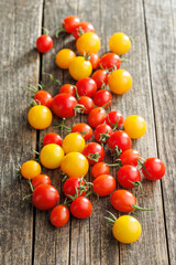 Wall Mural - Different colorful cherry tomatoes on wooden table.