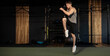 © Home-stock - Energetic man doing fitness exercise, warming up and lifting leg, full length shot, gym interior