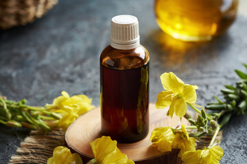 Wall Mural - Evening primrose oil in a dark glass bottle with fresh Oenothera biennis flowers