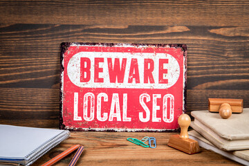 Local Seo. Beware sign with text on a wooden texture office table