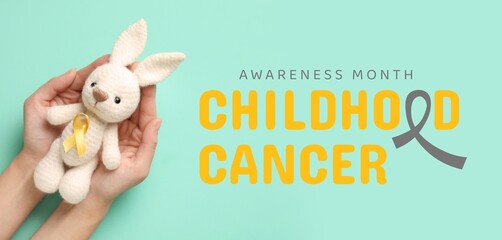 Sticker - Hands with toy and golden ribbon on turquoise background. Banner for Childhood Cancer Awareness Month