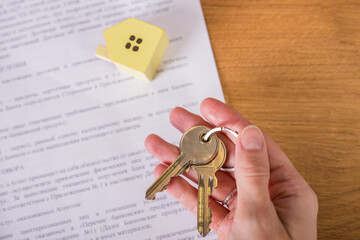 Real estate agent handed over the key to new home, marking a successful investment in business of property, whether it be a house or an apartment. Real estate agent giving house key to customers.