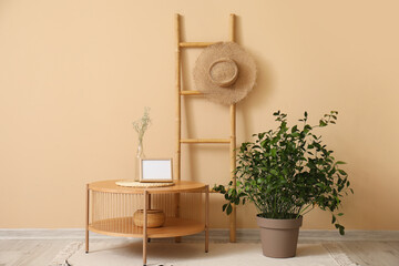 Wall Mural - Wooden coffee table with blank frame and houseplant near beige wall