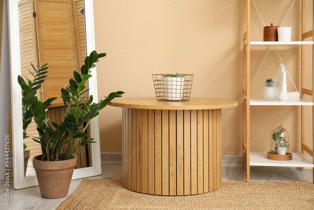 Coffee table, mirror, houseplant and shelving unit near beige wall