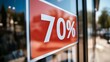 © Taras Vykhopen - Large discount sign showing 70 percent off at a retail store during a busy shopping day