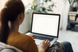 © Prasanth - Young woman using laptop computer at home. Blank empty white screen mock up. Freelance, student lifestyle, education, web conference, video call, technology and online shopping concept