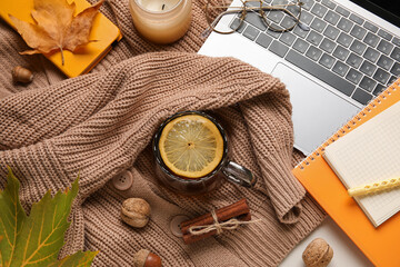 Wall Mural - Composition with cup of tea, modern laptop and autumn decor on knitted sweater