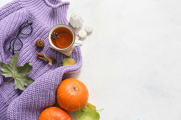 Poster - Composition with stylish knitted sweater, eyeglasses, cup of tea and autumn decor on light background