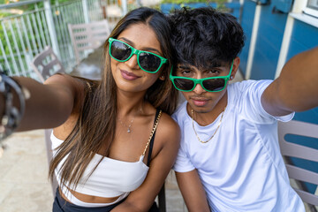 beautiful young teenage couple with funny faces having fun taking a selfie on an a terrace