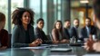 © Thanthara - group of professional people sitting at a table in a boardroom listening to one woman talking about business strategy