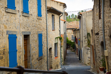 Wall Mural - Medieval old houses with blue shutters on narrow street of French town Lagrasse