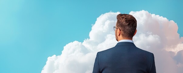 A man in a suit gazes at the blue sky and clouds, contemplating possibilities and new opportunities in a professional setting.