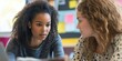 © kwanchaift - Two educators in a close-up shot analyzing a student?s work with serious and thoughtful expressions as they collaborate in a colorful classroom