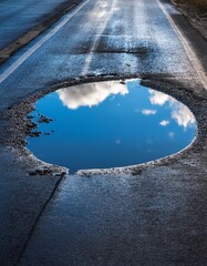 Canvas Print - Reflection of clouds in a puddle on a road in winter