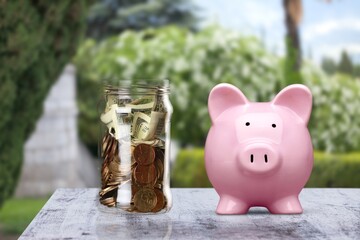 Poster - Saving money concept, coins in piggy bank on nature background